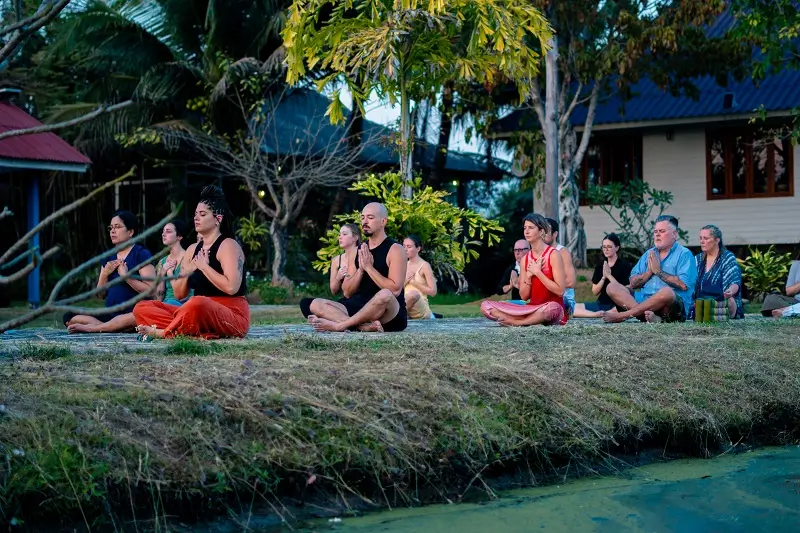 Evening group meditation beside the water at the Chiang Mai campus
