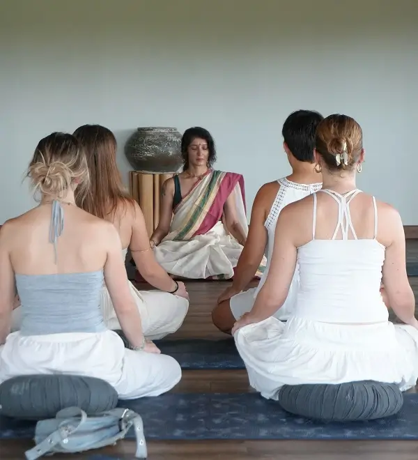 A teacher leading a small seated group through practice