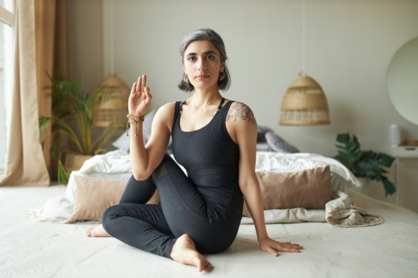 Woman Practicing Seated Yoga Twist Pose Indoors Woman Practicing Seated Yoga Twist Pose Indoors