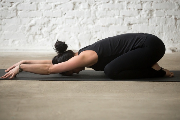 A Woman Practicing Balasana for Neck and Shoulder Pain Relief A Woman Practicing Balasana for Neck and Shoulder Pain Relief